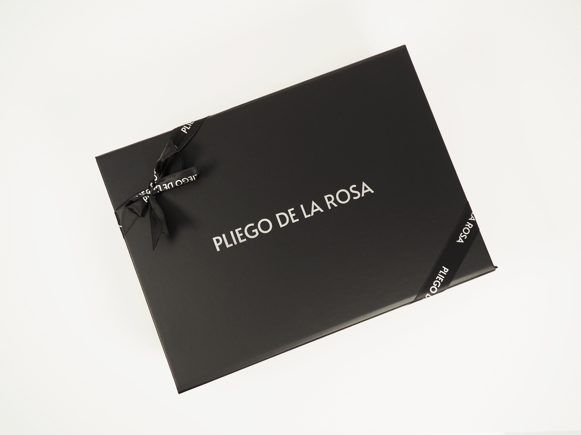 Bolso Pliego De La Rosa envuelto con papel y lazo, mostrando packaging de lujo y presentación exclusiva.