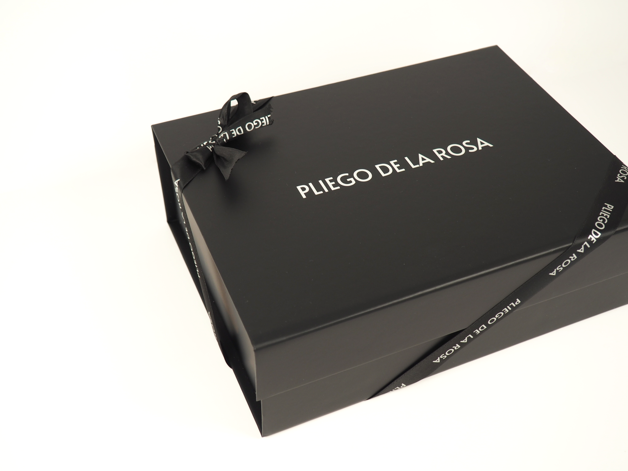 Bolso Pliego De La Rosa envuelto con papel y lazo, mostrando packaging de lujo y presentación exclusiva