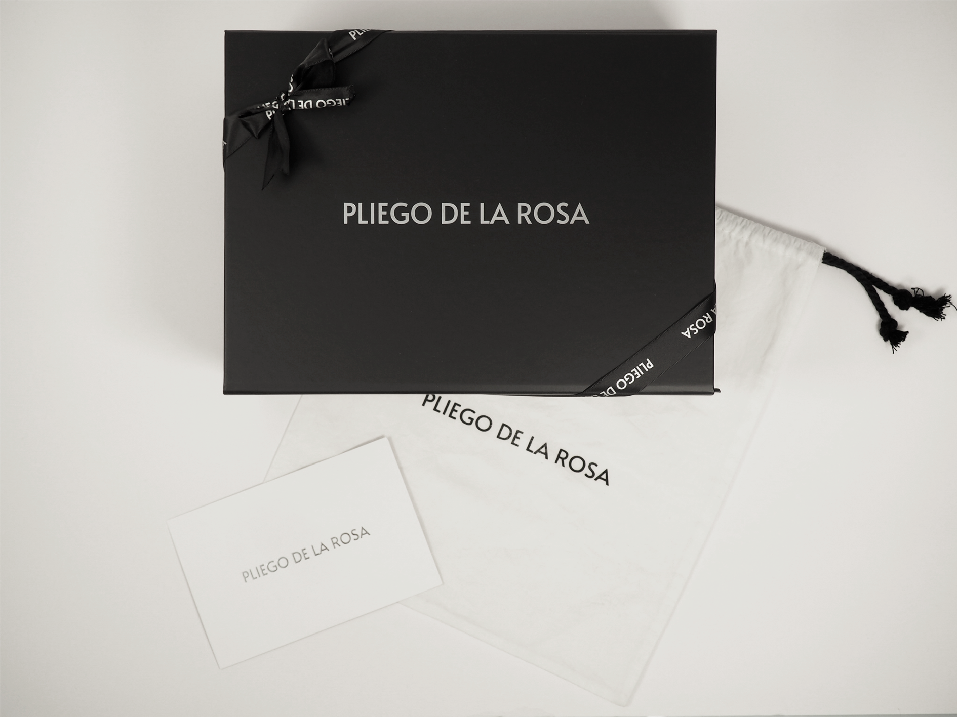 Bolso de lujo de Pliego De La Rosa siendo embalado cuidadosamente, mostrando packaging de lujo elegante
