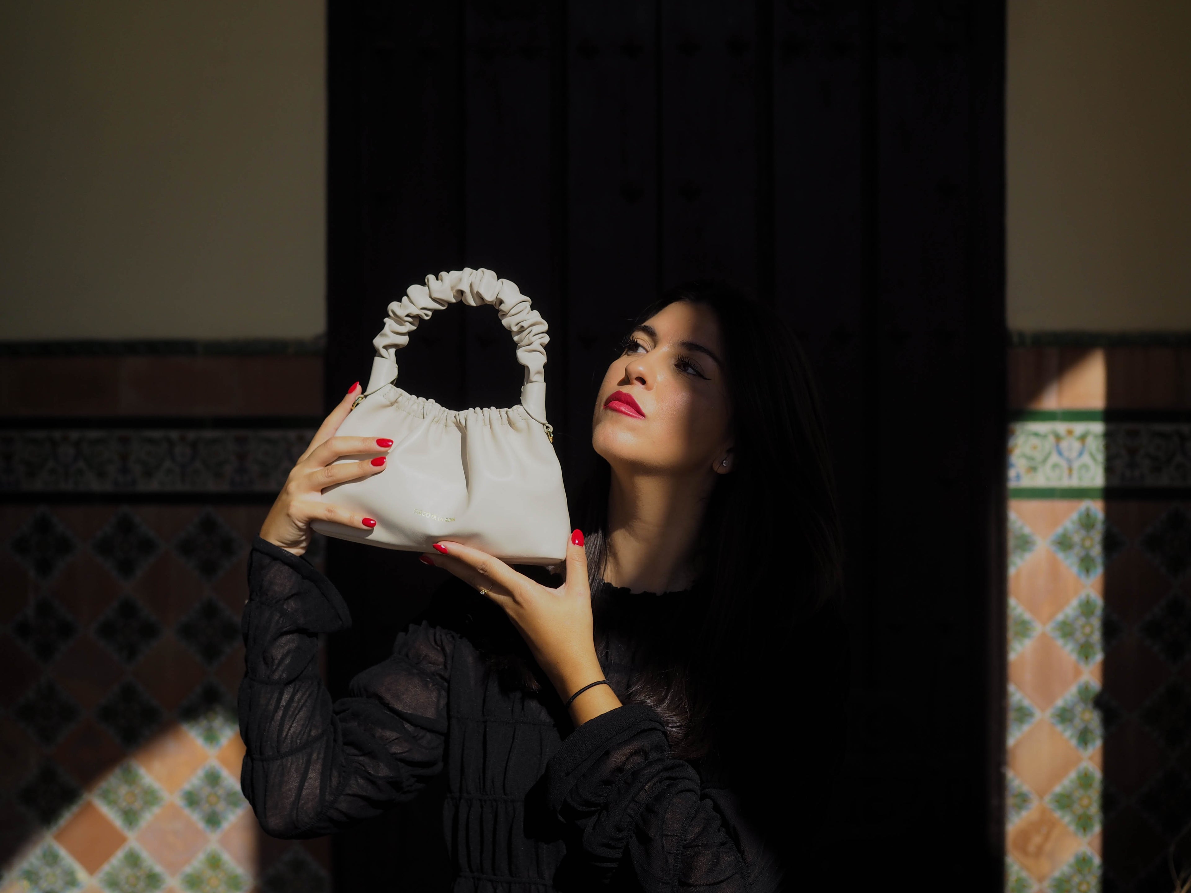 MODELO POSANDO CON MINI TANGO IVORY EDITION EN PATIO ANDALUZ, BOLSO DE PIEL DE LUJO ARTESANAL HECHO EN UBRIQUE HECHO EN ESPAÑA